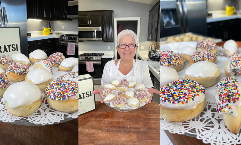 A smiling woman with short white hair and glasses holds a plate of cookies topped with white icing and colorful sprinkles, standing in a modern kitchen. Close-up shots of the cookies frame the image.