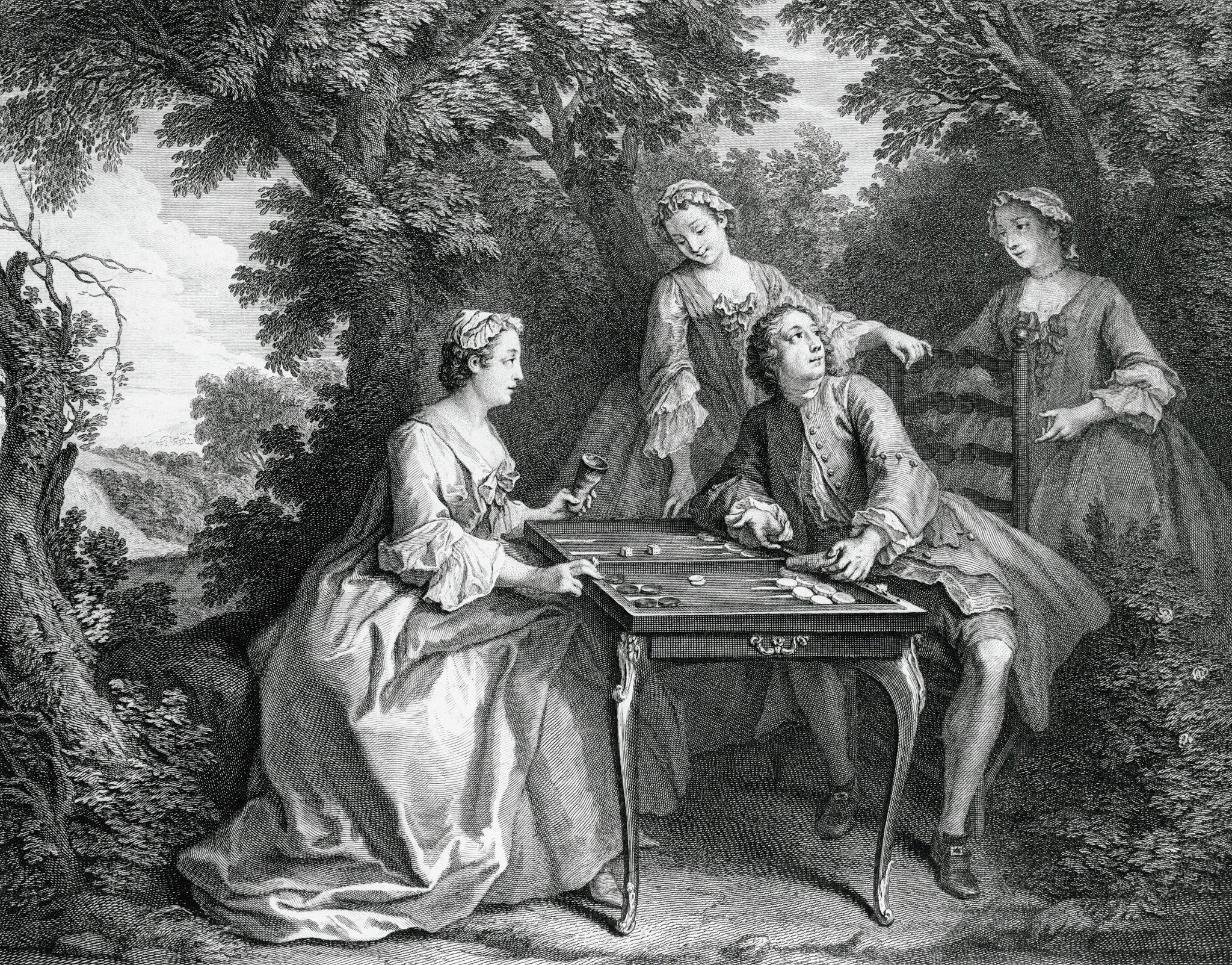 Four elegantly dressed people from the 18th century play a board game at a table outdoors amid trees. Two women watch as a seated man and woman focus on the game, all in period clothing.