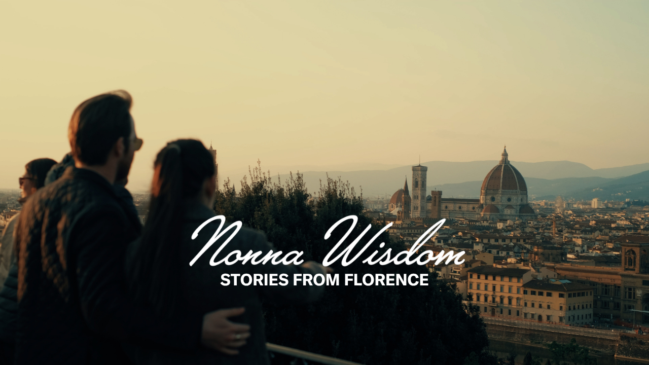 A couple stands together overlooking Florence at sunset, with the cityscape and Florence Cathedral in view. Text on the image reads: Nonna Wisdom - Stories from Florence.