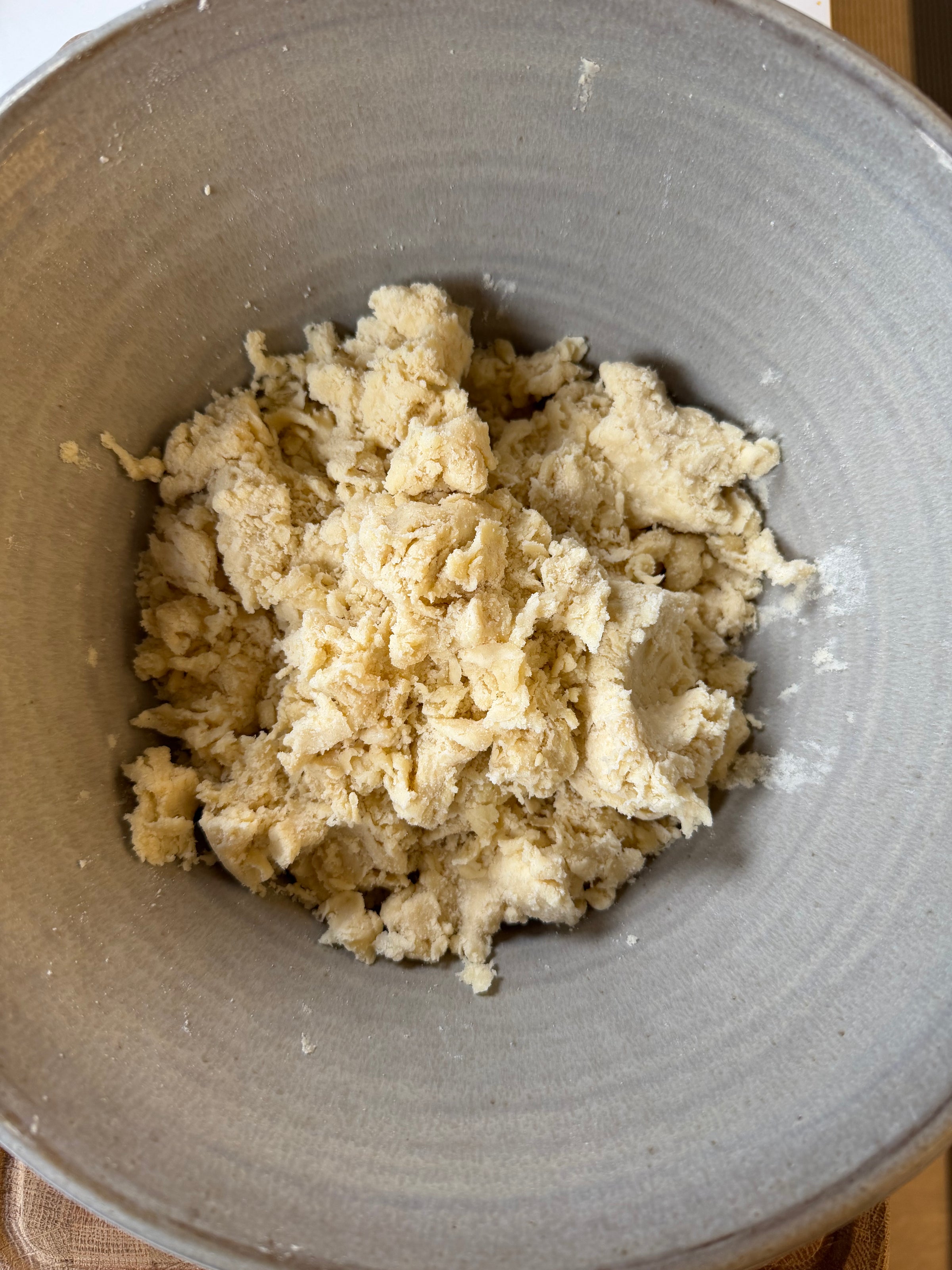 Shaggy, unkneaded dough in a large ceramic bowl.
