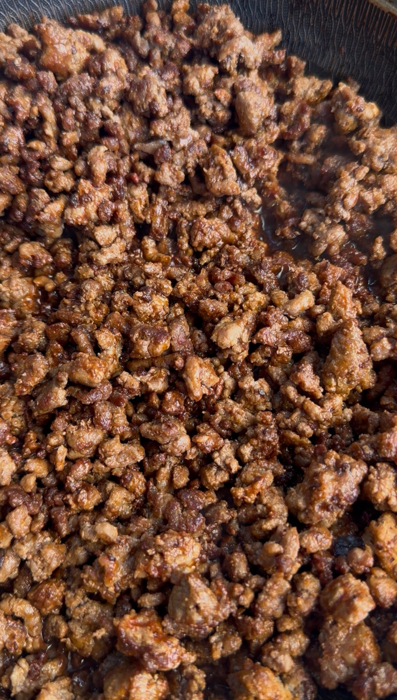 Cooked ground beef, browned and seasoned, fills the frame. The meat appears crumbly, juicy, and evenly cooked, with small bits and a rich, brown color.