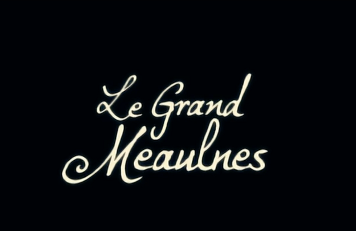 The image displays the title Le Grand Meaulnes in elegant, cursive white lettering on a black background.