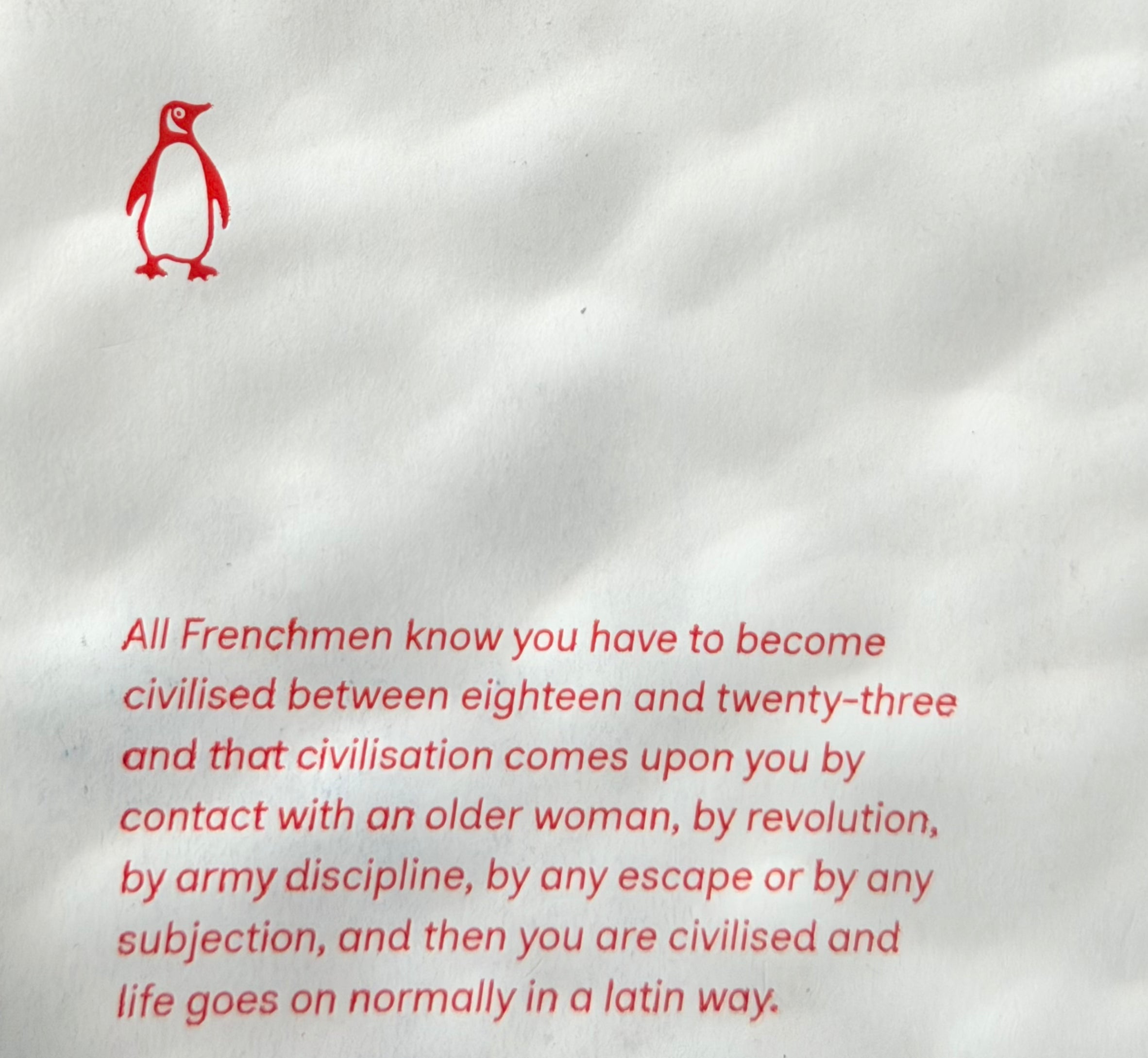 A red penguin logo above red text about Frenchmen becoming civilized between eighteen and twenty-three through experiences like contact with an older woman, revolution, or army discipline.