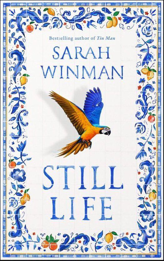 Book cover for Still Life by Sarah Winman, featuring a blue and yellow parrot in flight, bordered by a decorative blue floral and fruit pattern on a white background.