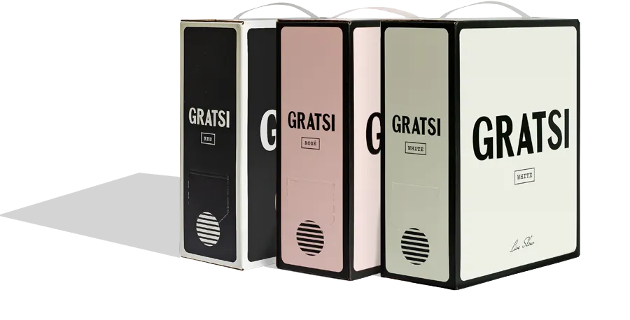 Four rectangular Gratsi wine boxes in black, blush pink, cream, and off-white, each with a handle on top and large bold GRATSI text on the front. They are standing upright on a light background.