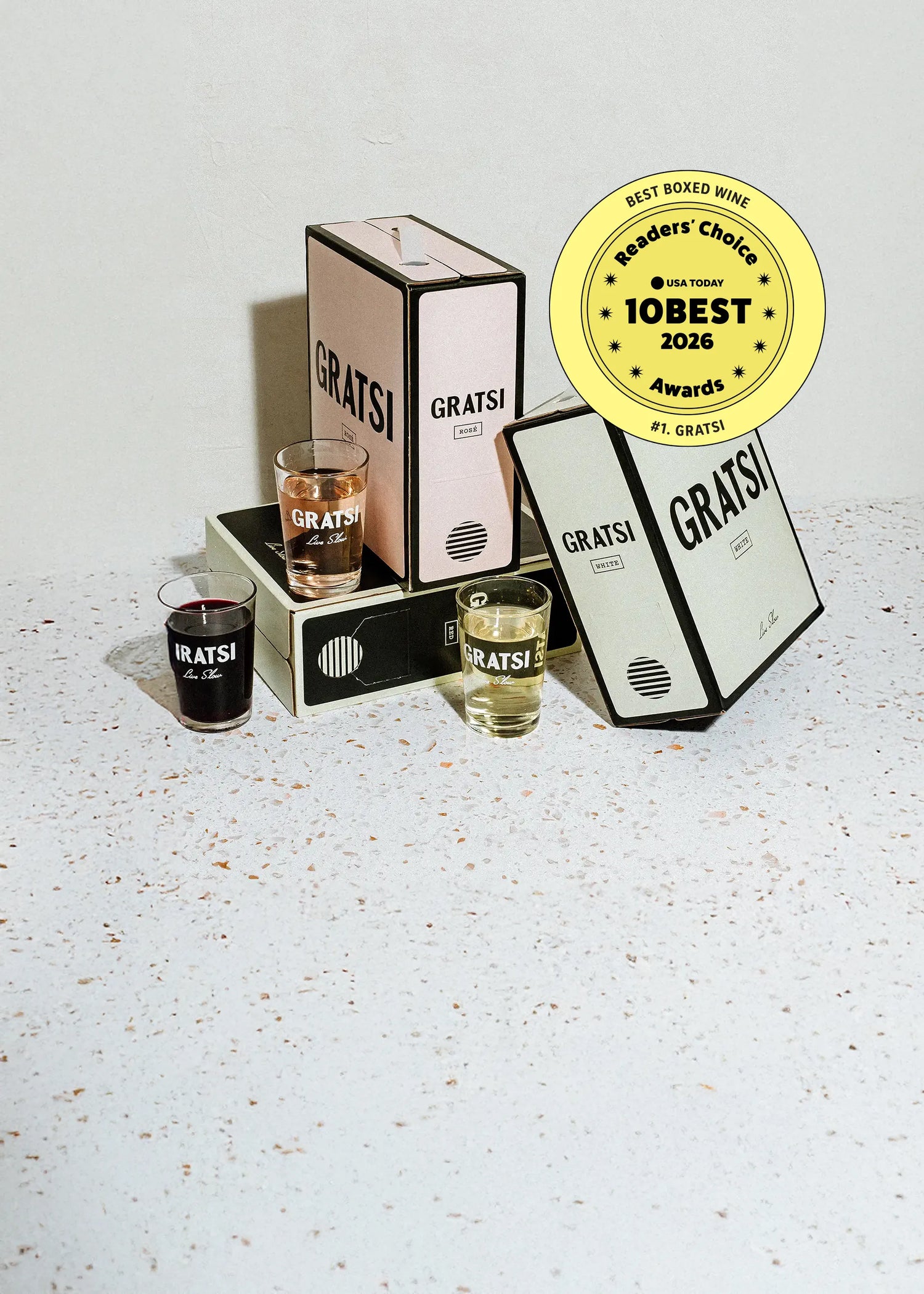 Three Gratsi boxed wines and three glasses with different colored wines beside them. A yellow badge reads Best Boxed Wine, USA Today, 10Best 2026, #1 Gratsi, Readers Choice Awards..