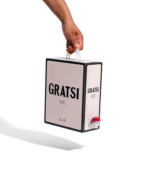 A hand holds a Gratsi Rosé Wine box with black text and a red spout against a white background, suggesting a refreshing, zero sugar experience.